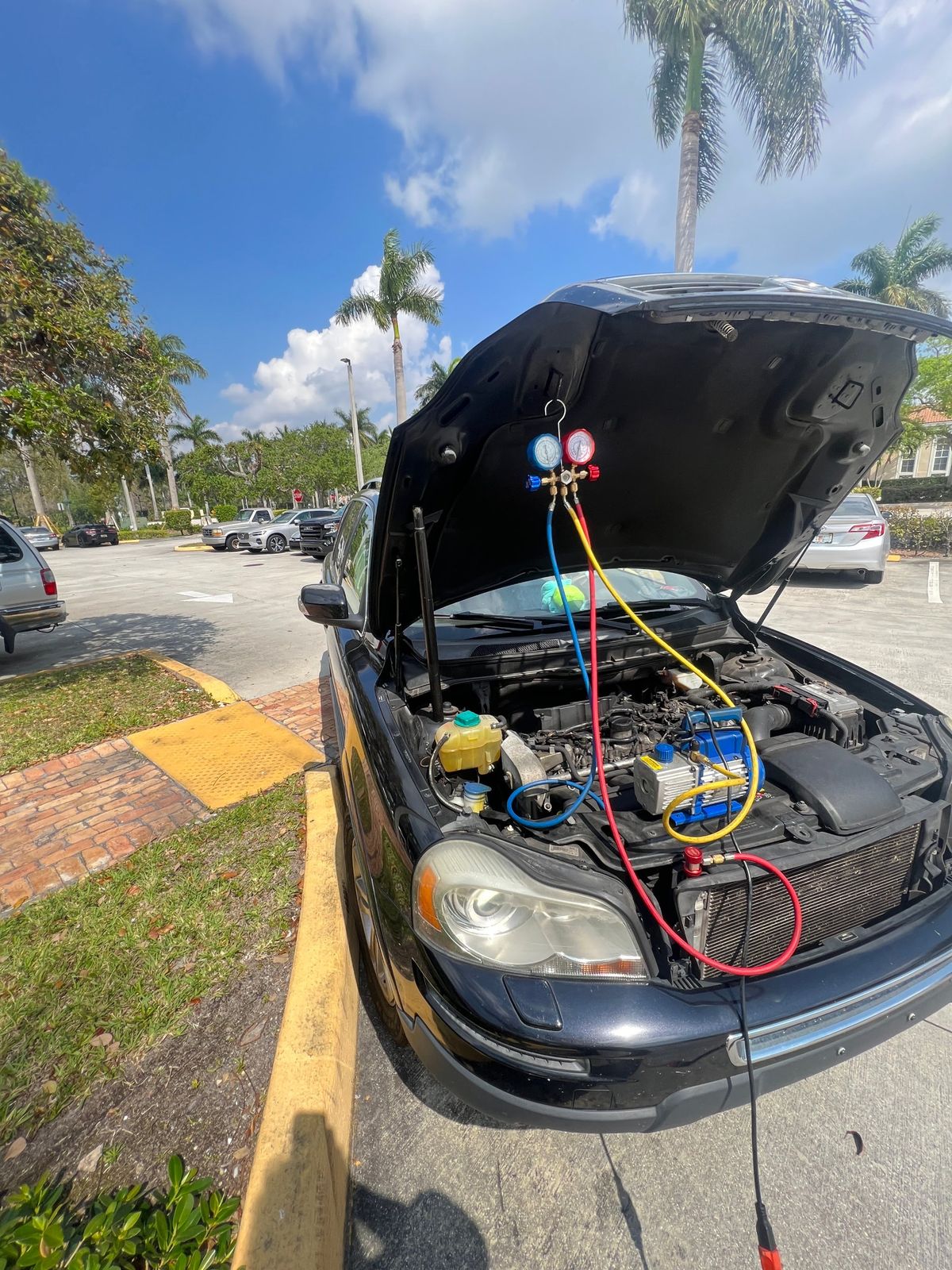 Air conditioning manifold gauges connected to a car to test system pressures on site