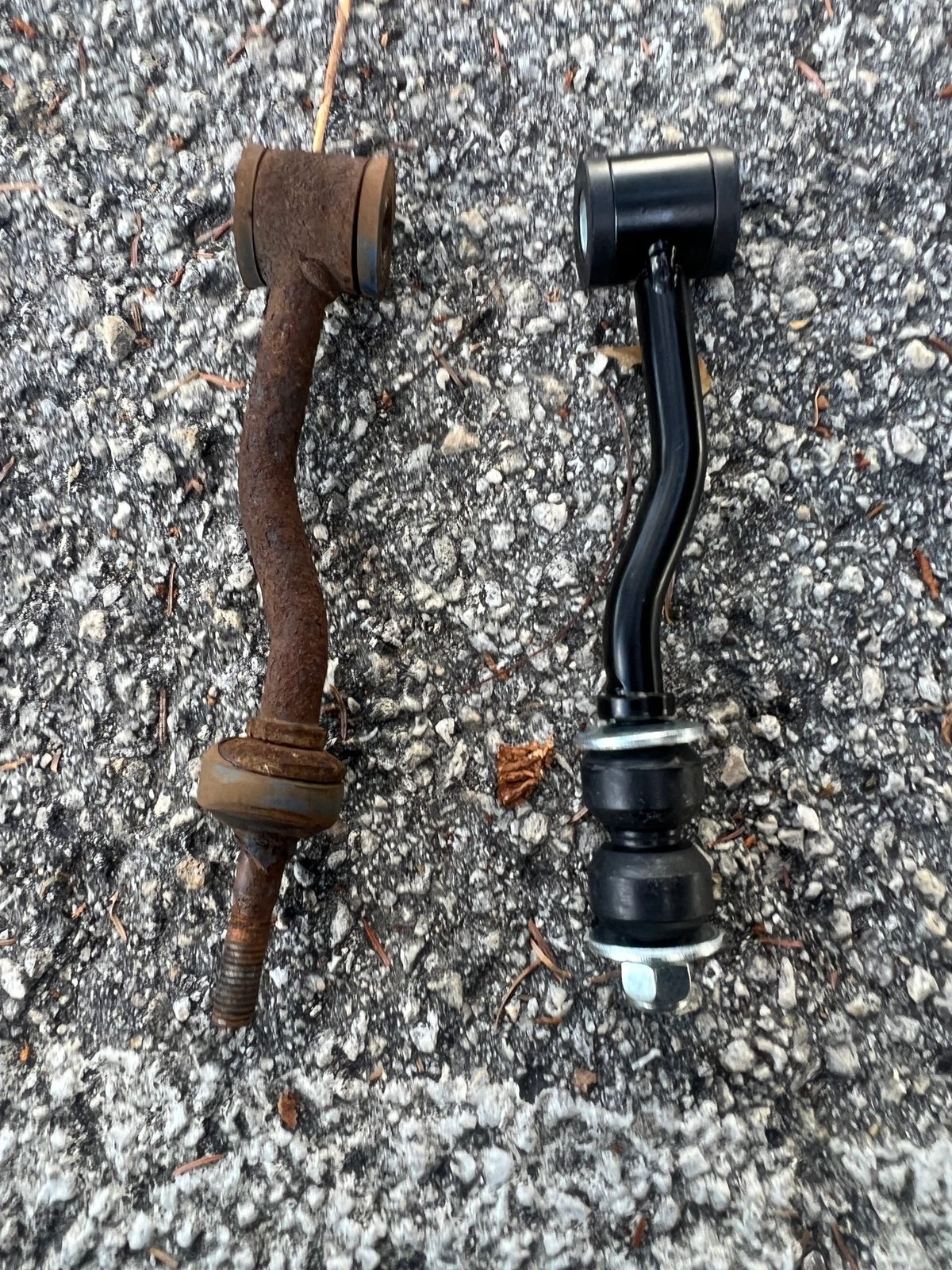 Worn sway bar link next to its replacement showing corrosion and play